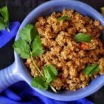 Bowl of Cauliflower Stir fry with lemon wedge on side.