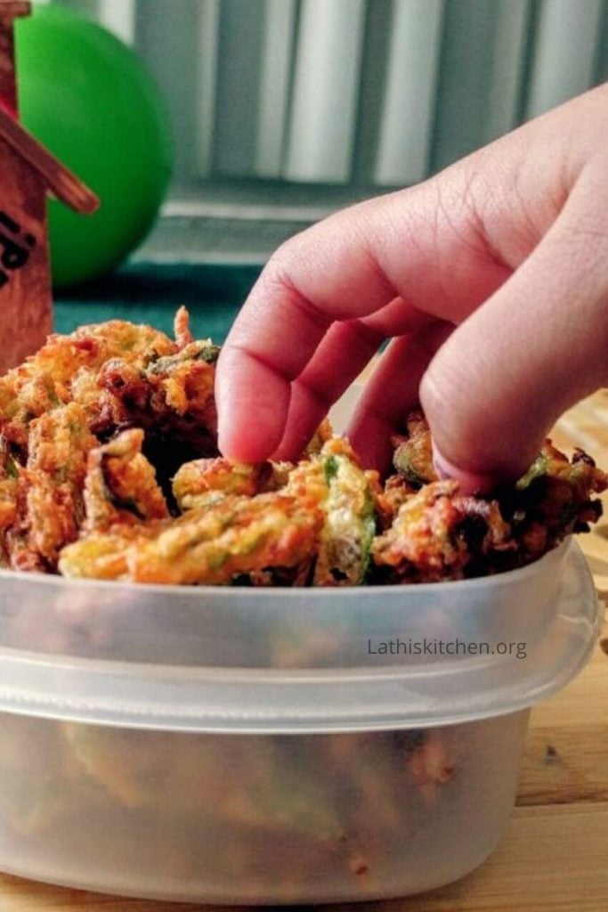 A hand picking crispy okra fry.