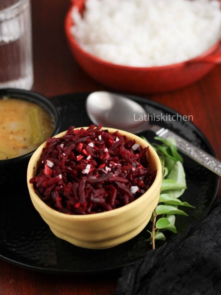 An yellow bowl with beetroot stir fry with coconut and a sprig of curry leaves along with a spoon.