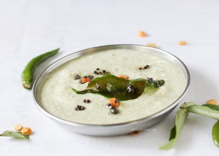 A plate of coconut chutney with green chili and curry leaves.