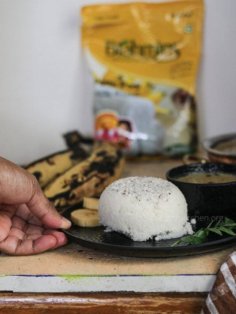 A hand taking a plate with steamed rice flour.