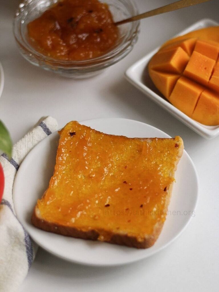 A slice of bread with mango jam spread.