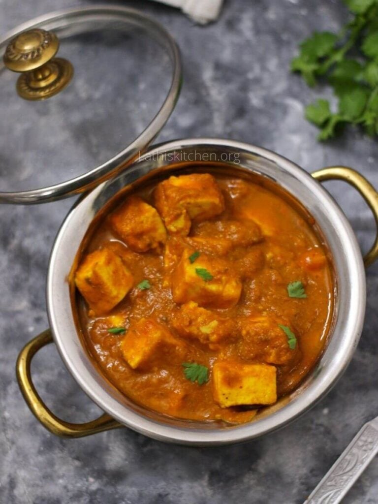 A bowl of creamy paneer butter masala with chopped cilantro garnished.