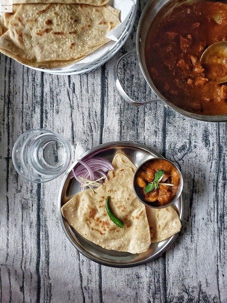 A plate with roti and Kashmiri chicken curry.