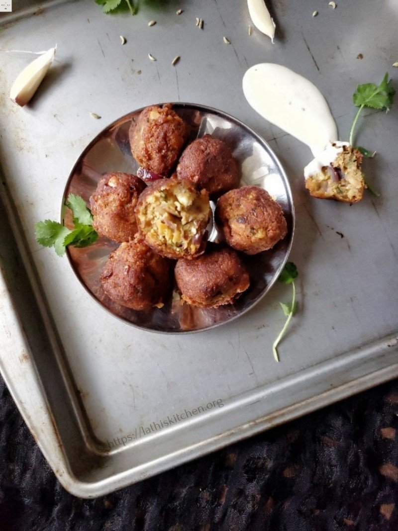Few pumpkin falafel on a plate placed on a baking pan.