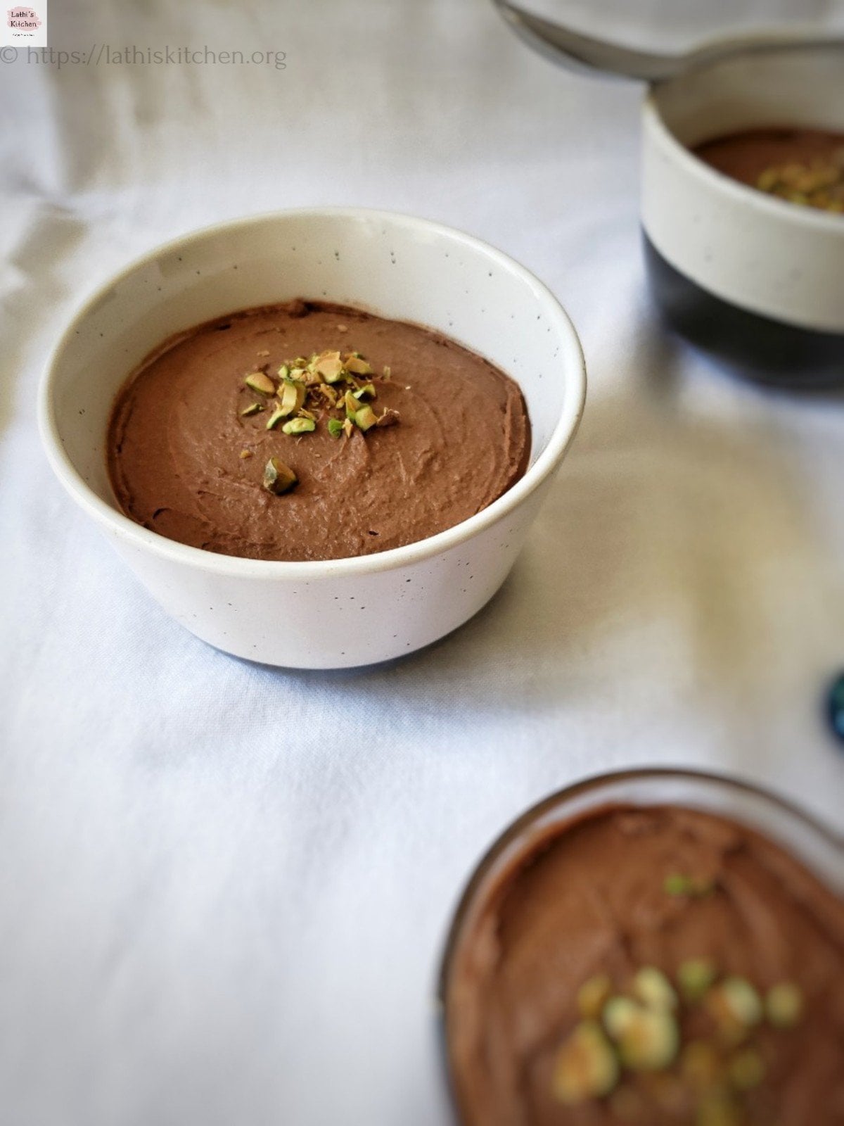 Bowl of sweet potato chocolate pudding with chopped pistachios on top.