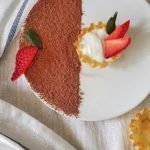 Plate of phyllo mini cups with yogurt filling and strawberry slices.