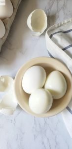 Eggs in a bowl with peeled skin.