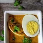 Bowl of Chettinad Egg curry with chopped cilantro.