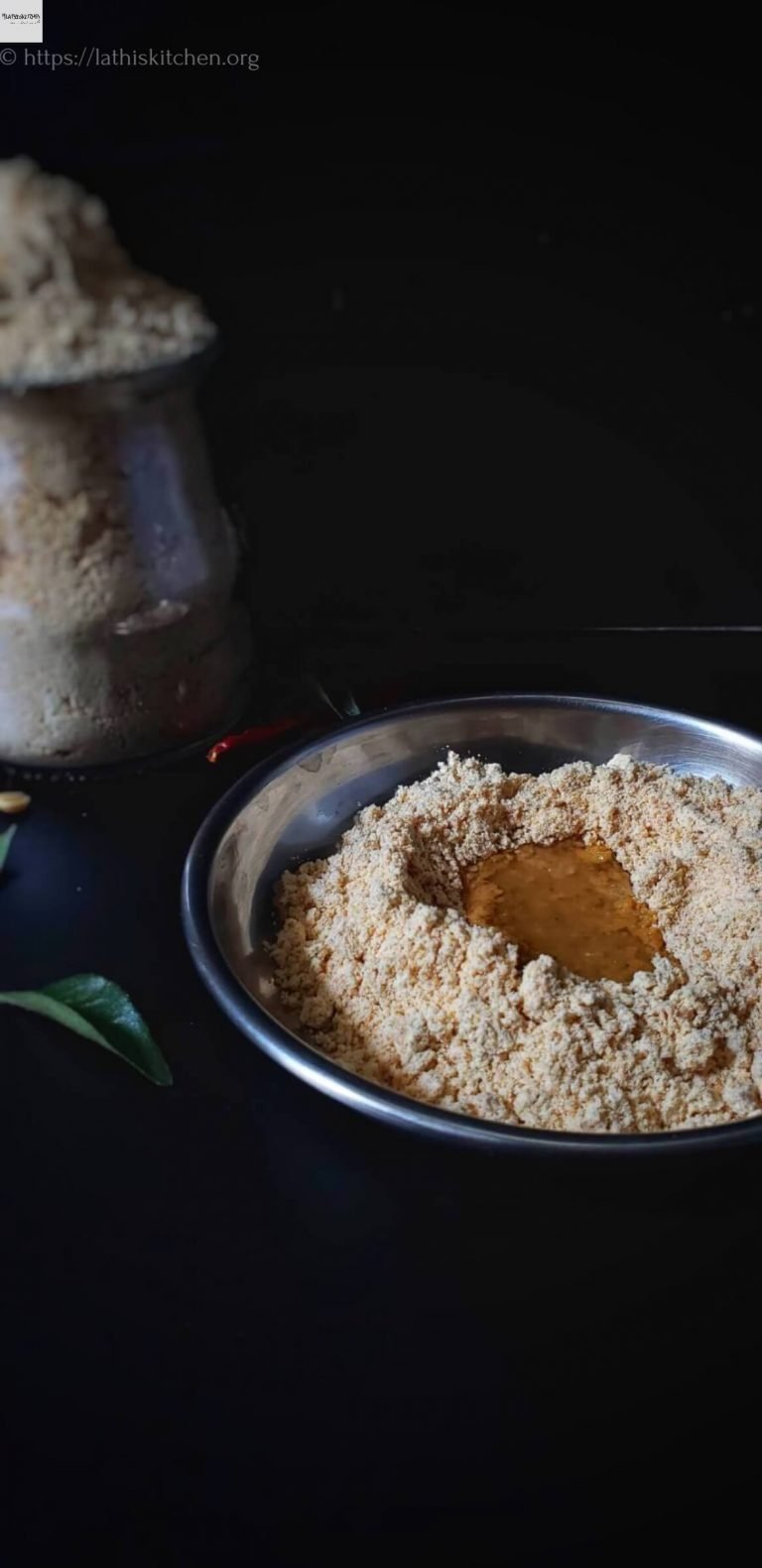 A plate with paruppu podi and oil.