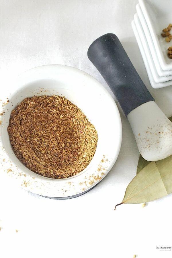 Kadai masala ground in mortar and pestle.