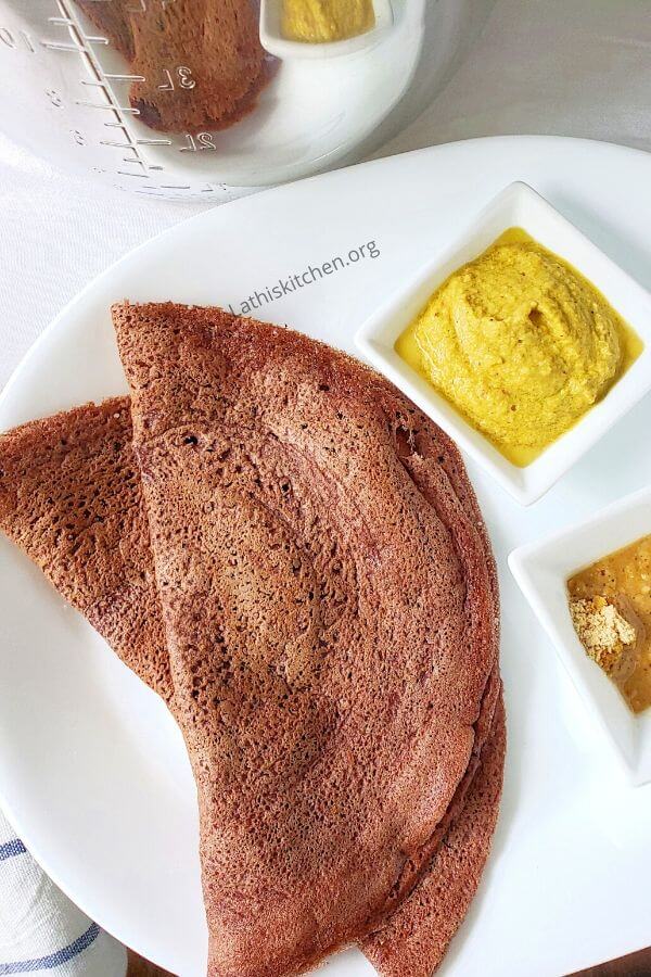 A plate with two Ragi Dosa and chutney.