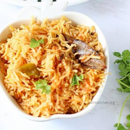 A bowl of easy tomato rice with a bunch of cilantro on the side.