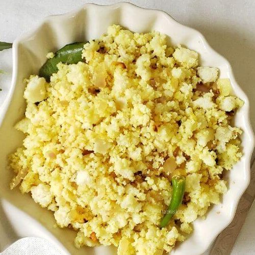 A bowl of Idli Upma and a spoon on side.