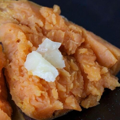 Fluffy cooked sweet potato with butter smeared on it.