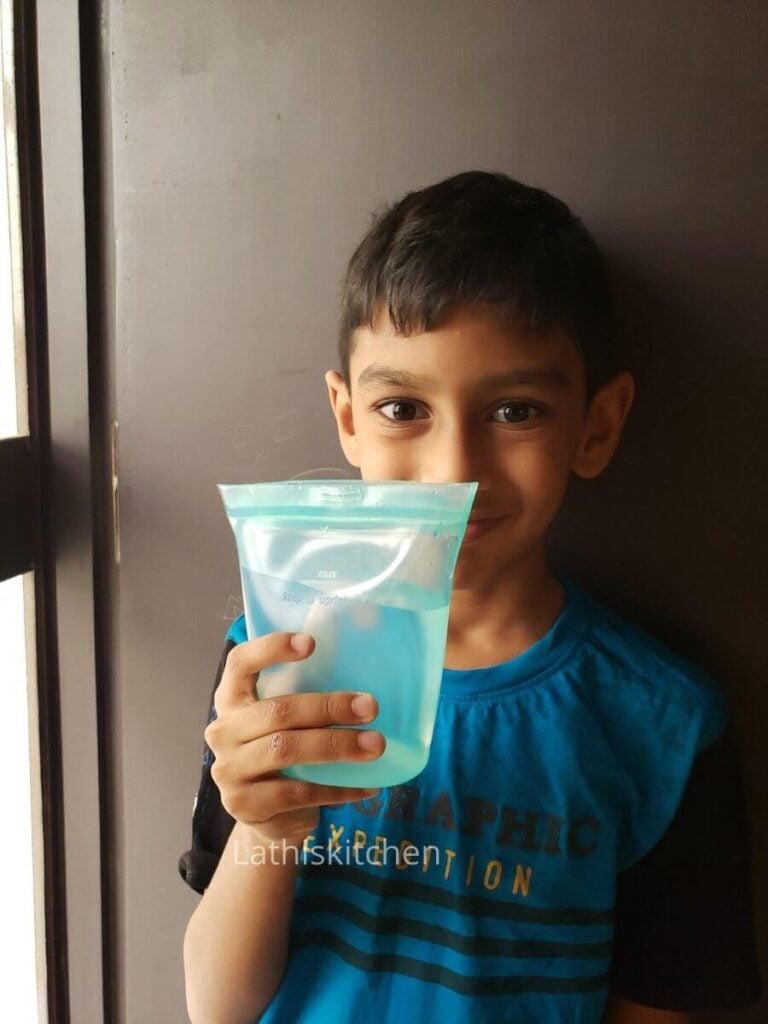 A kid holding ziptop pouch with water.