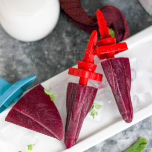 3 Black plum popsicles in a plate.