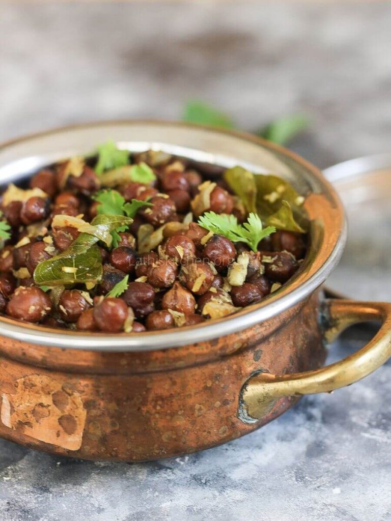 A bowl of black chickpeas sundal with cilantro garnishes.